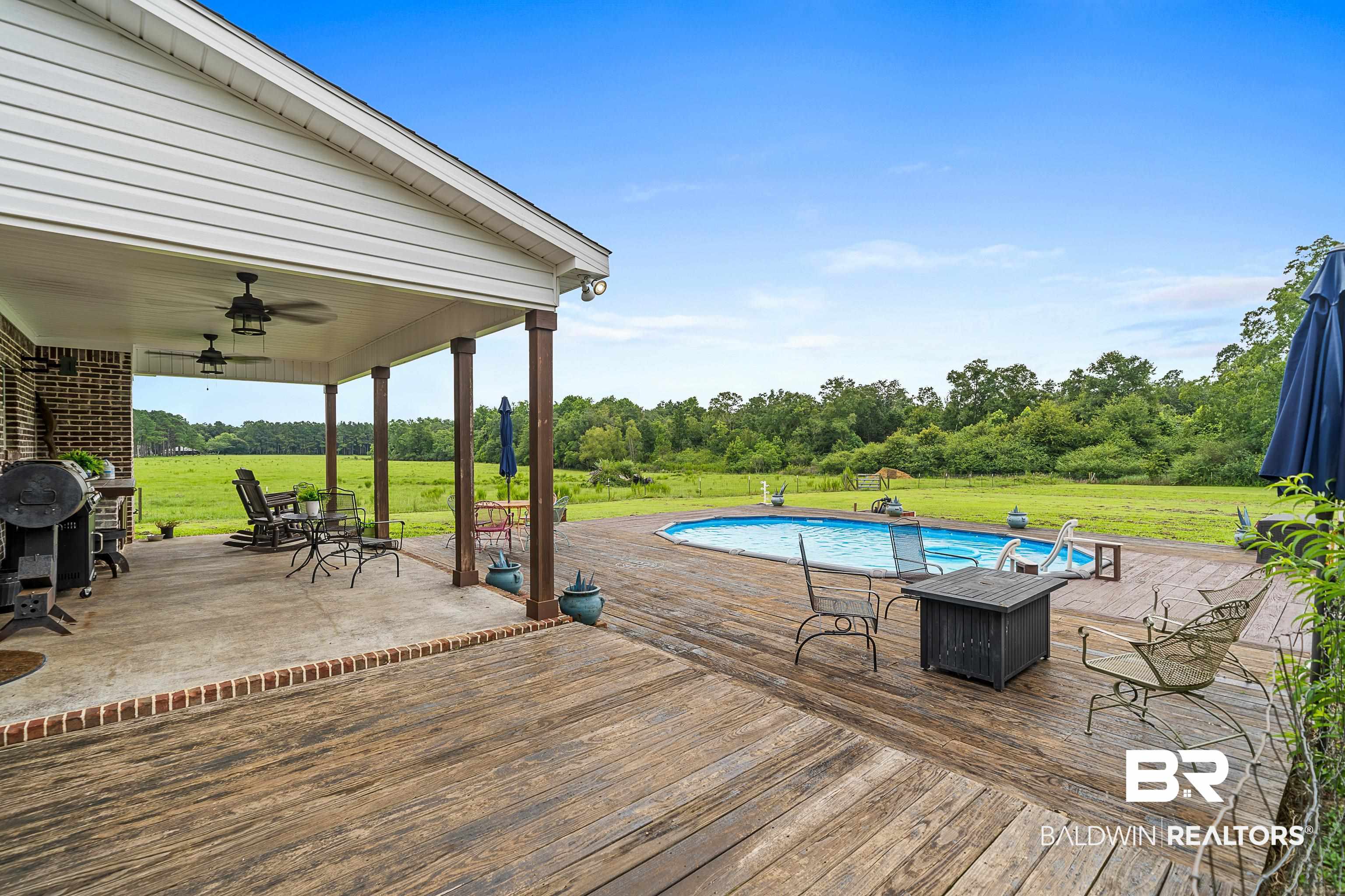 25212 Reeves Lane Elberta, AL 36530 - Photo 19 of 28 Deck with a ceiling fan, a lawn, an outdoor pool, a patio area, and outdoor dining space