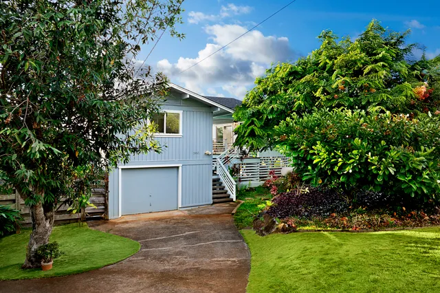 a front view of a house with a garden and yard