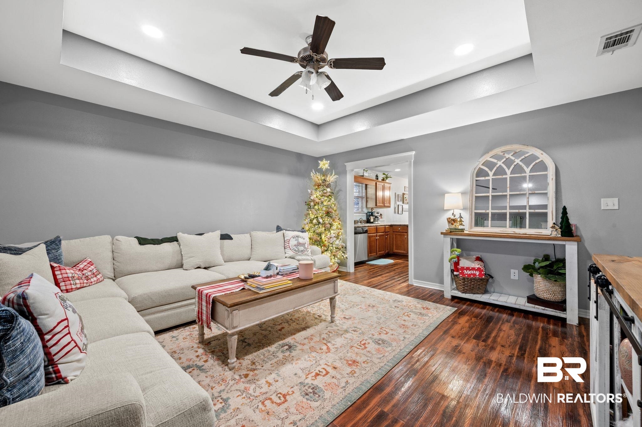 9366 Fox Run Court Semmes, AL 36575 - Photo 8 of 29 Living room with dark hardwood / wood-style flooring, a tray ceiling, and ceiling fan