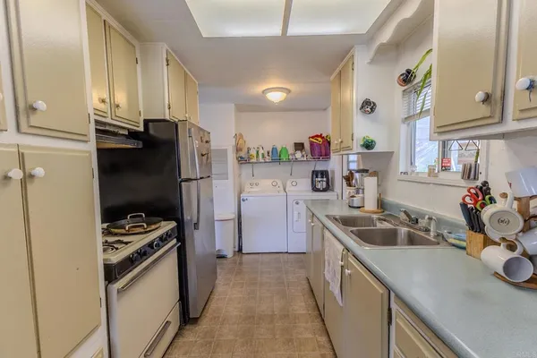 a kitchen with sink refrigerator and cabinets