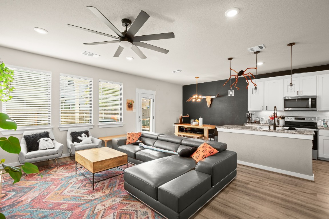 195 C Waterside Road Buda, TX 78610 - Photo 1 of 27 Living room featuring recessed lighting, light wood-style flooring, a chandelier, and a ceiling fan