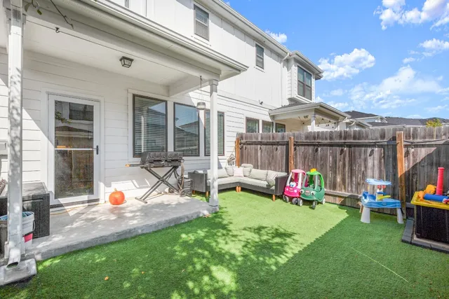 a view of a chair and table in backyard of the house