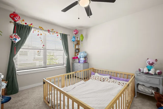 a living room with a baby crib furniture and a chandelier