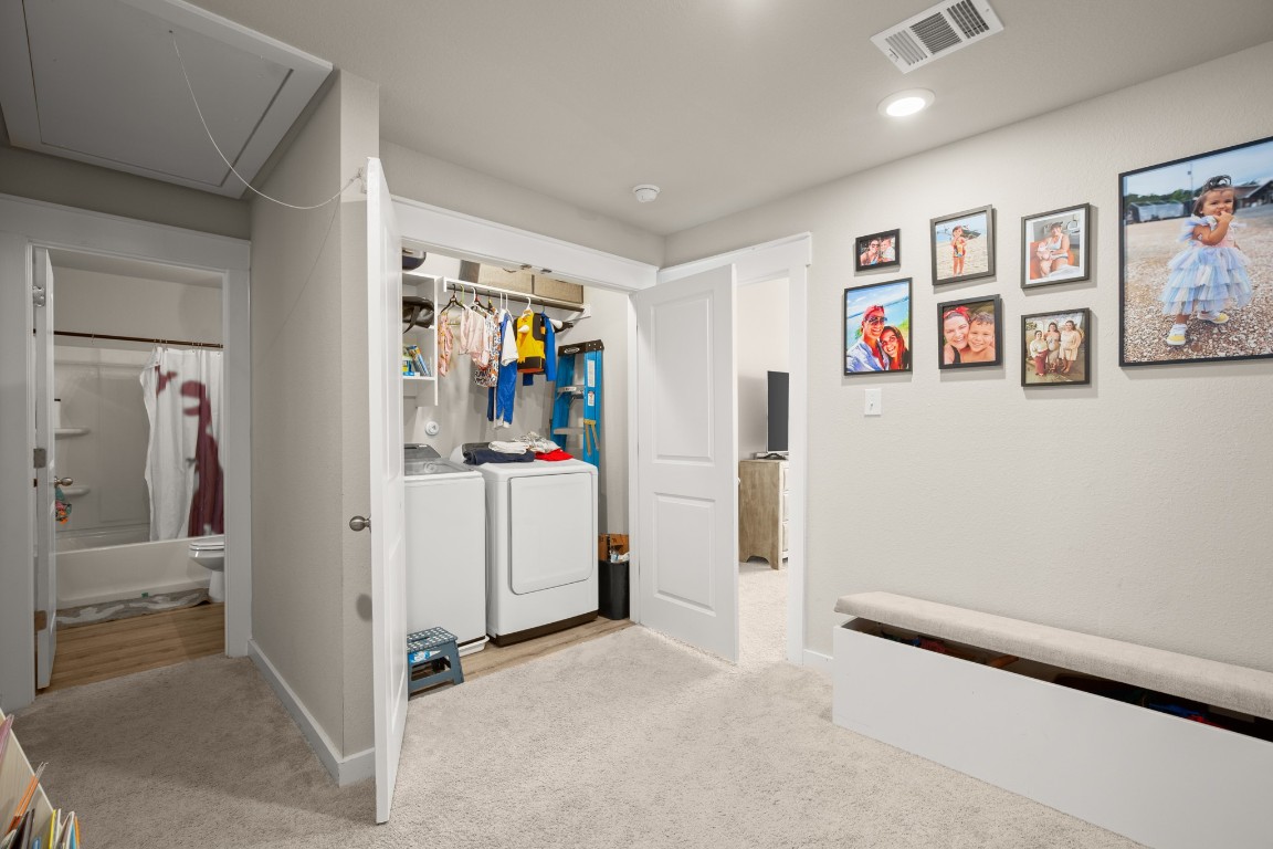 195 C Waterside Road Buda, TX 78610 - Photo 15 of 27 Laundry room featuring attic access, light colored carpet, and washer and dryer