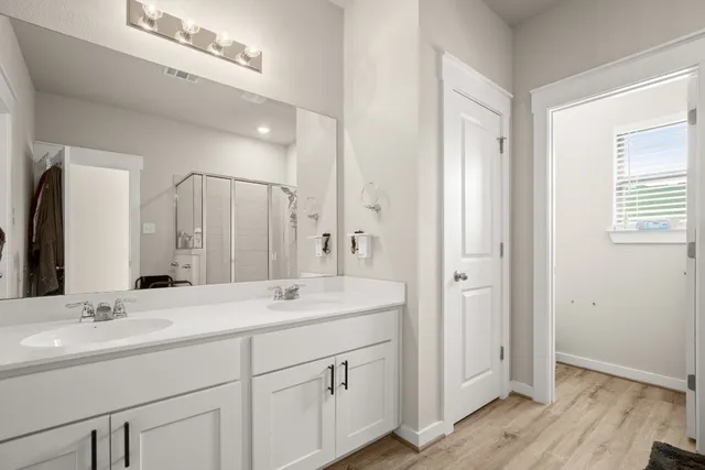 a bathroom with a double vanity sink and mirror