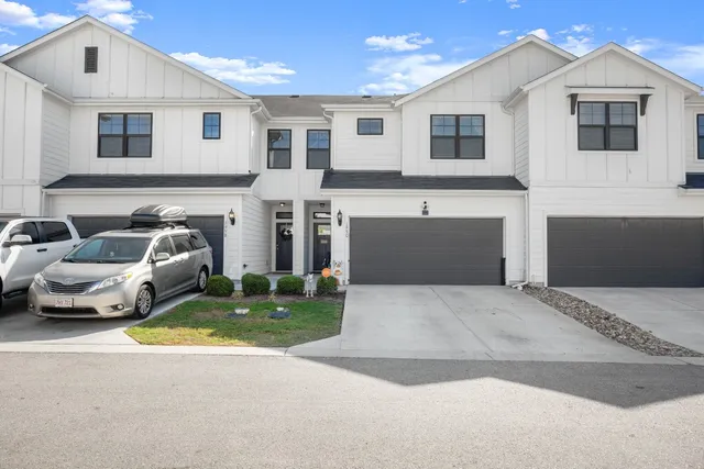 a front view of a house with cars parked