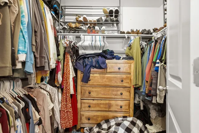 a view of walk in closet with clothes and shoes