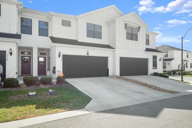 a front view of a house with garden and garage