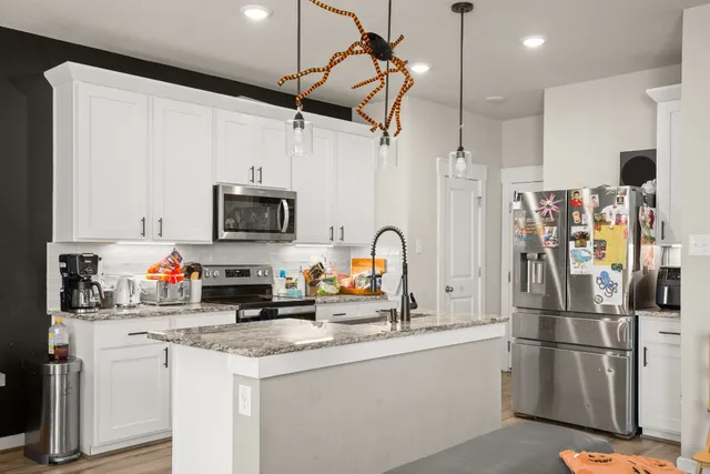 a kitchen with stainless steel appliances granite countertop a refrigerator sink and microwave