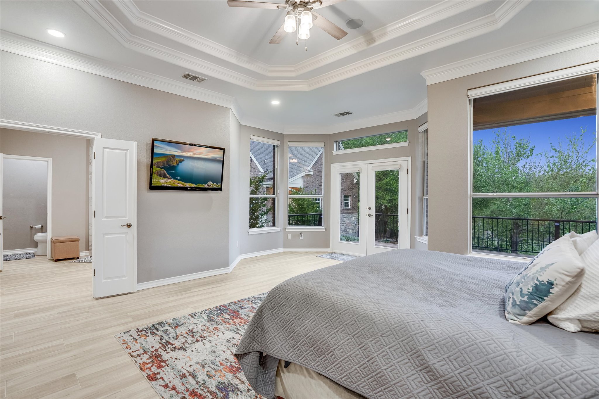 1400 Tom Sawyer Road Austin, TX 78737 - Photo 15 of 40 Spacious primary suite with tray ceiling, natural light, and views of the backyard.