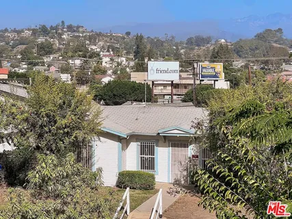 an aerial view of residential houses with outdoor space and trees