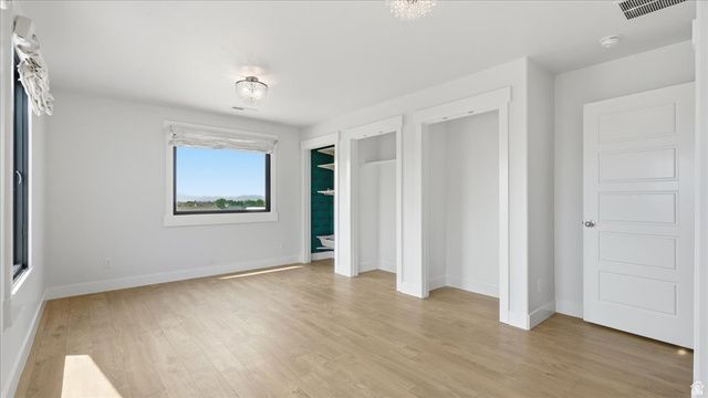 2038 East Ranch Road Eagle Mountain, UT 84005 - Photo 27 of 66 Bright interior space featuring light wood-finish flooring, white walls, and a large window with a distant landscape