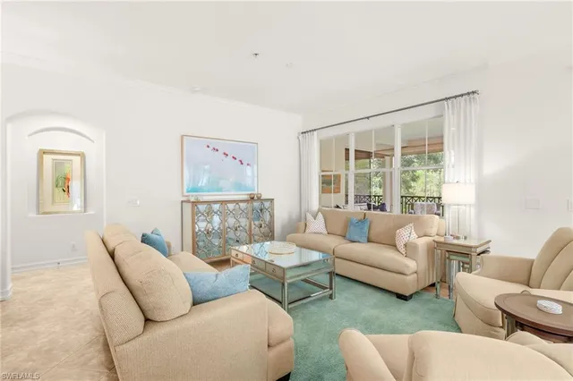 a large bed sitting in a bedroom next to a window and a lamp