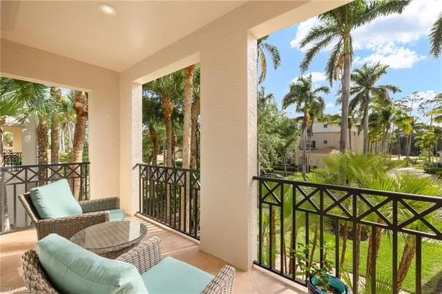 a view of swimming pool with lawn chairs and plants