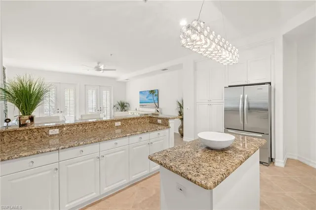 a dining room with furniture a chandelier and large windows