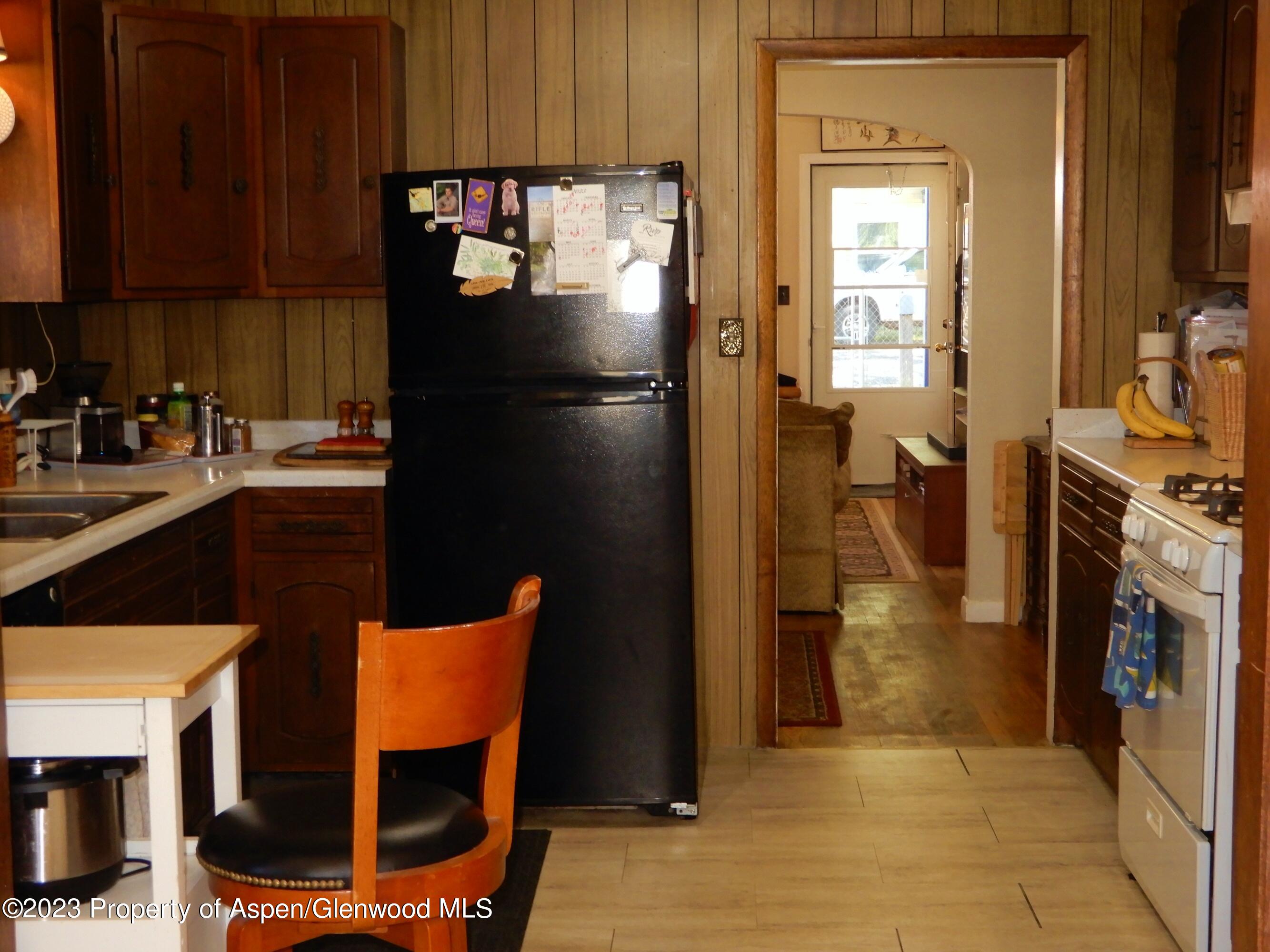 129 East 11th Street Rifle, CO 81650 - Photo 3 of 24 a kitchen with a refrigerator a stove top oven a sink and dishwasher