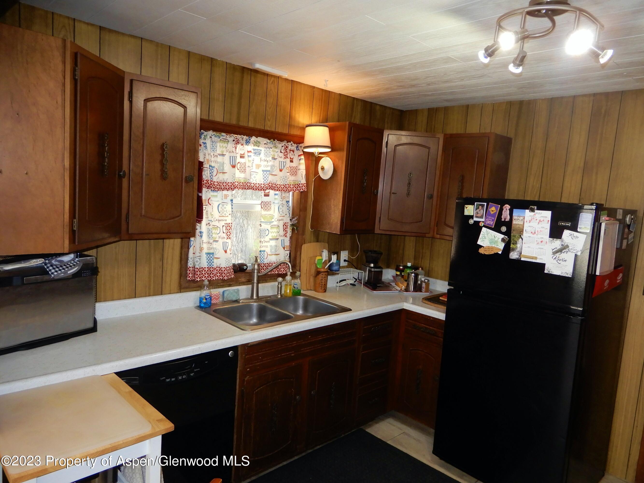 129 East 11th Street Rifle, CO 81650 - Photo 4 of 24 a kitchen with a sink and a refrigerator
