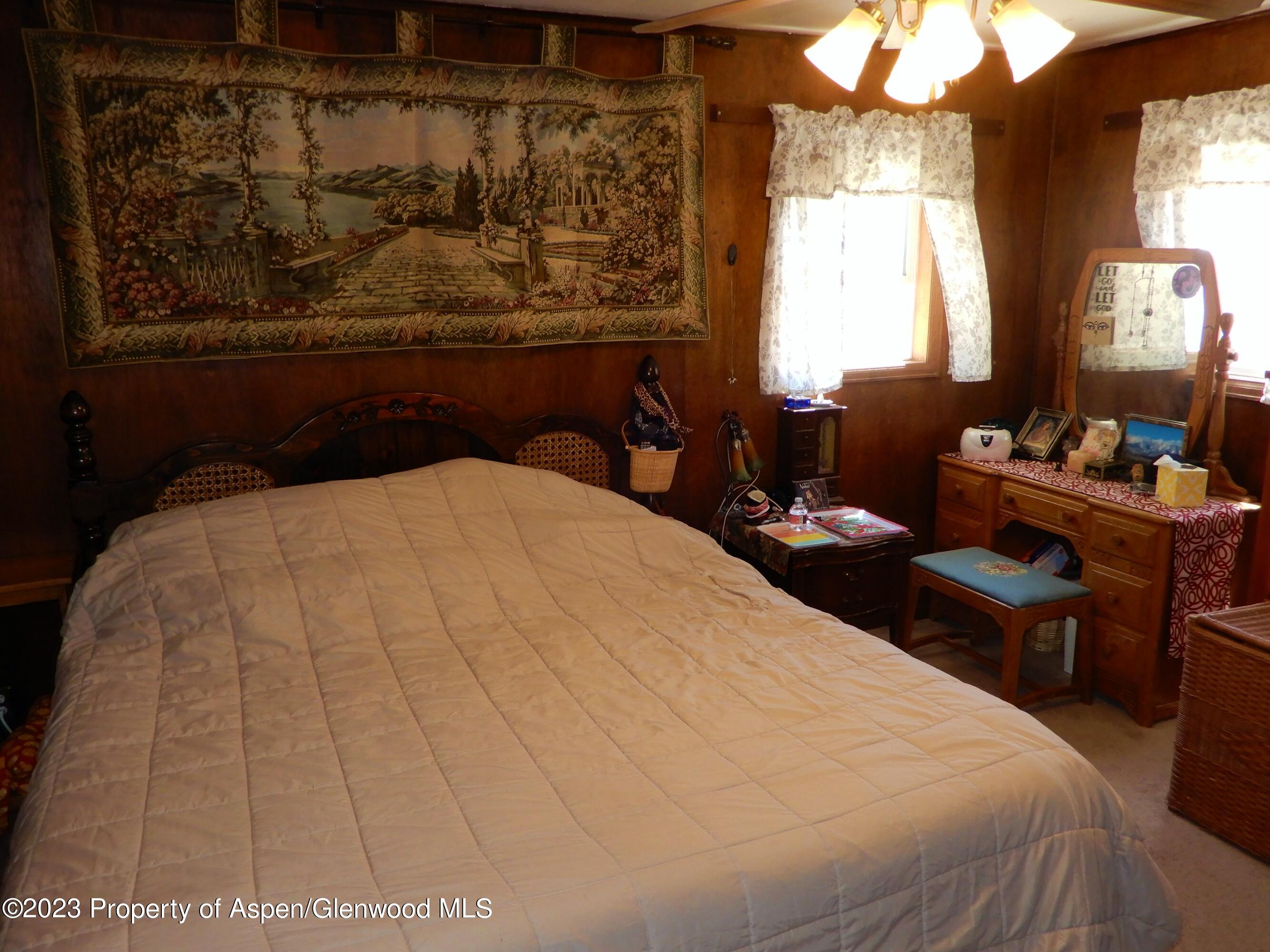 129 East 11th Street Rifle, CO 81650 - Photo 9 of 24 a bed sitting in a bedroom next to a window