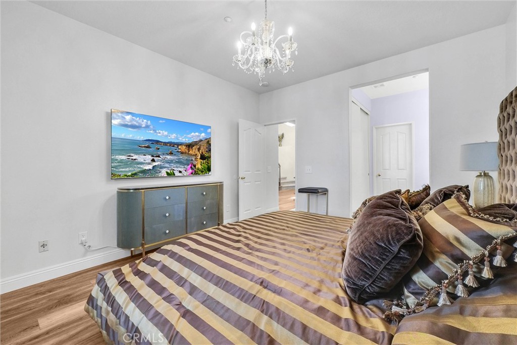11499 Bridgeway Drive Riverside, CA 92505 - Photo 26 of 70 a bedroom with a bed and a chandelier
