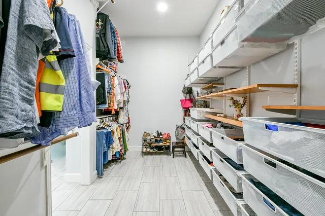 a view of walk in closet with clothes and shoes