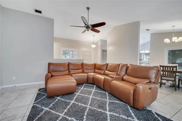 a living room with furniture a ceiling fan and a rug