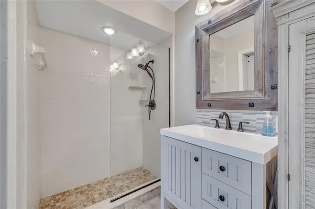 a bathroom with a sink a vanity a mirror and a shower