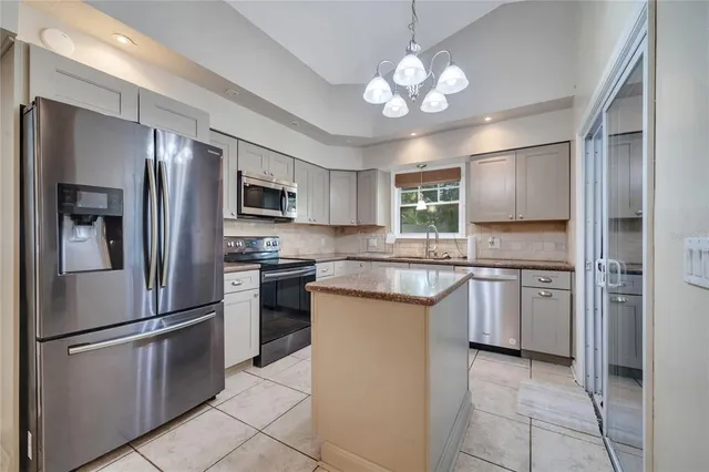a kitchen with granite countertop stainless steel appliances cabinets and a refrigerator
