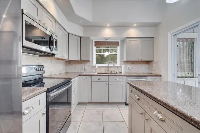 a kitchen with stainless steel appliances granite countertop a sink and a stove