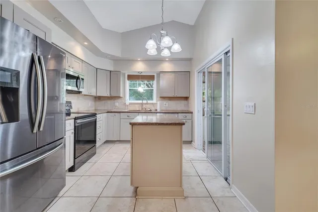 a kitchen with a refrigerator a sink and cabinets