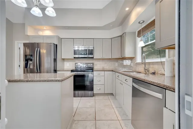 a kitchen with stainless steel appliances granite countertop a sink counter space cabinets and a large window