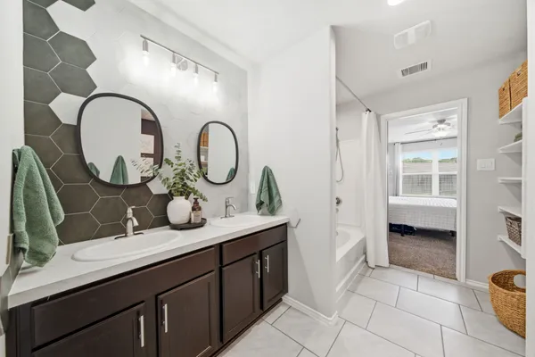 a bathroom with a granite countertop double vanity sink and a mirror