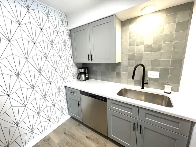 a kitchen with stainless steel appliances white cabinets and a stove top oven