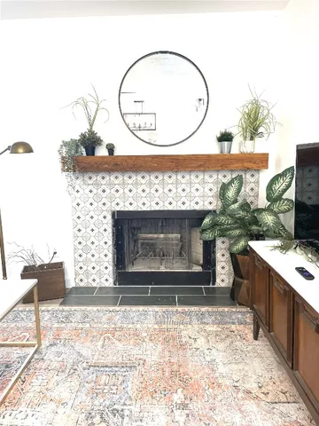 a living room with a fireplace furniture a rug and a window