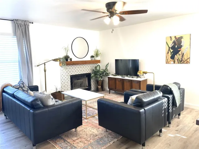 a living room with furniture a fireplace and a flat screen tv