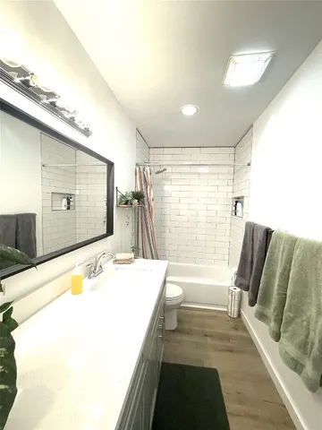 a bathroom with a tub sink and mirror