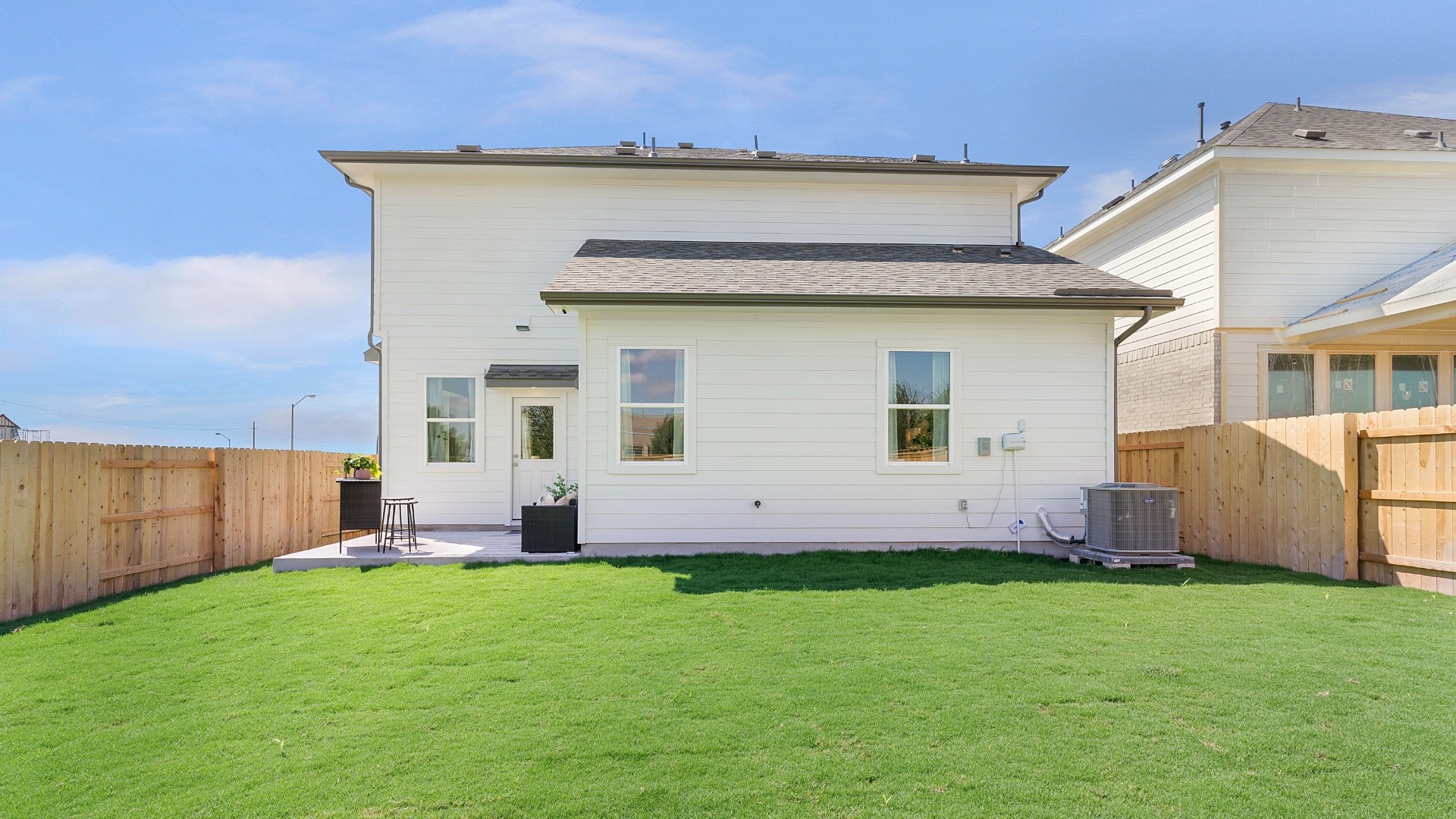 25812 Jasmine Sprig Lane Elgin, TX 78621 - Photo 26 of 33 A spacious backyard with vibrant green grass offers a welcoming outdoor living area.