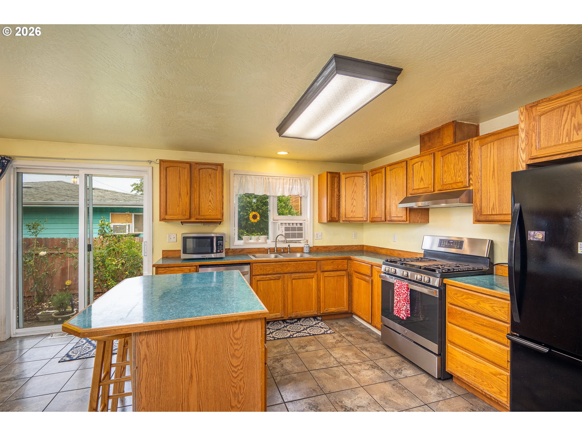 90 South 17th Street Cottage Grove, OR 97424 - Photo 7 of 23 a kitchen with stainless steel appliances granite countertop a sink and a refrigerator