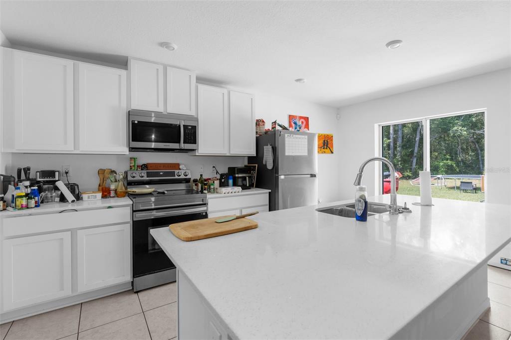 5637 East Tangelo Lane Inverness, FL 34453 - Photo 11 of 23 a kitchen with a sink a microwave and cabinets