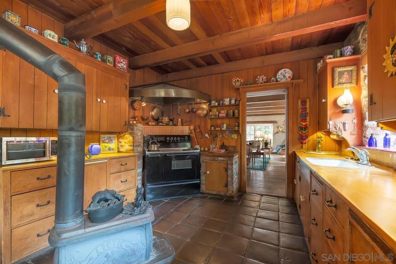 3754 Pine Hills Road Julian, CA 92036 - Photo 12 of 39 a kitchen with refrigerator and cabinets