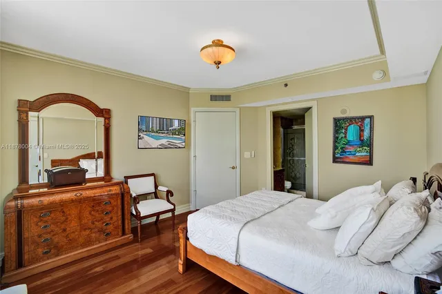 a bedroom with a large bed and wooden floor