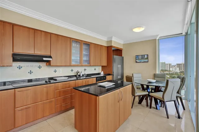 a view of a kitchen with a stove a kitchen island a table and chairs