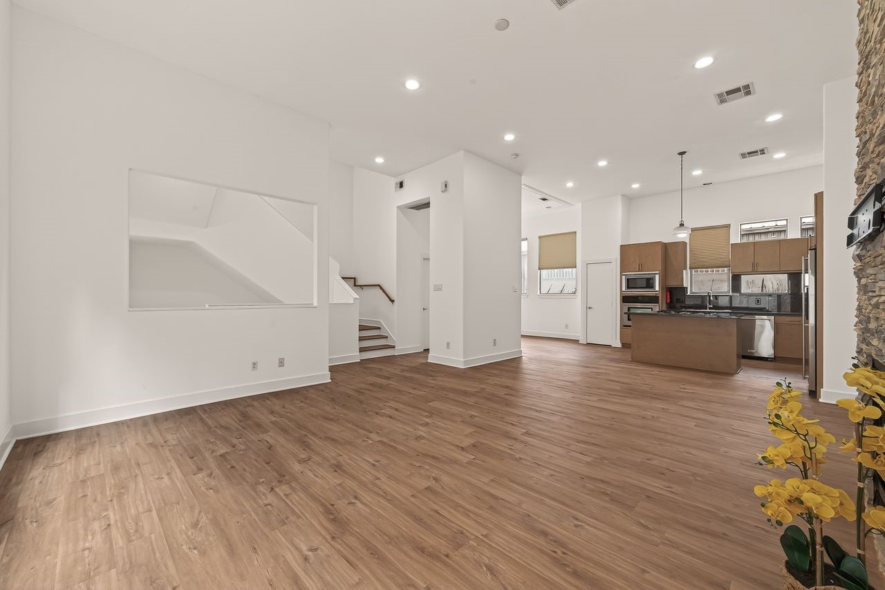 724 Ruthven Street Houston, TX 77019 - Photo 9 of 45 an empty room with wooden floor and large windows