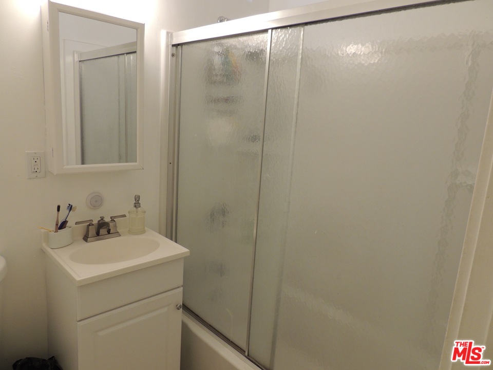 908 Victoria Avenue Venice, CA 90291 - Photo 22 of 25 a bathroom with a sink a mirror and a shower