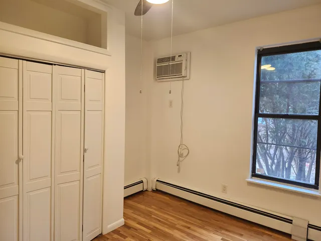 a view of a room with wooden floor and cabinet