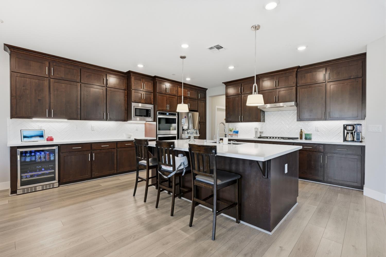 810 Broken Bit Court Rocklin, CA 95765 - Photo 17 of 47 a large kitchen with stainless steel appliances kitchen island granite countertop a large stove a sink dishwasher and cabinets with wooden floor