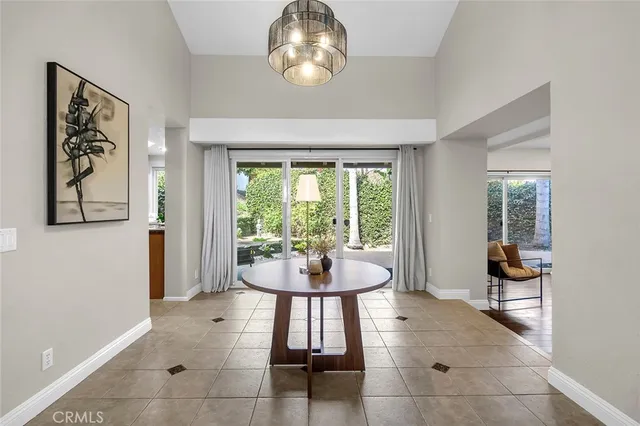 a dining room with chandelier and wooden floor