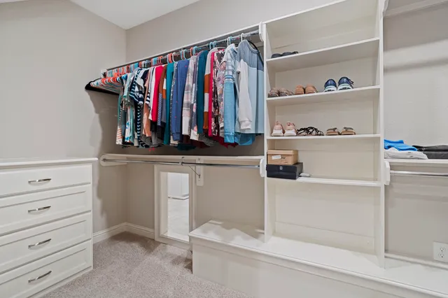 a large bedroom with a bed and a ceiling fan