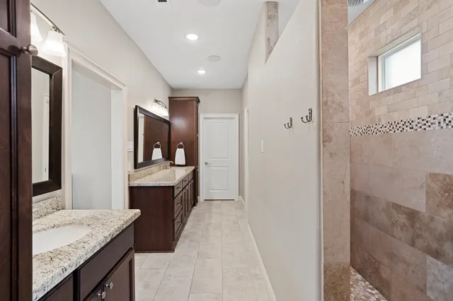 a bathroom with a granite countertop double sink and a mirror