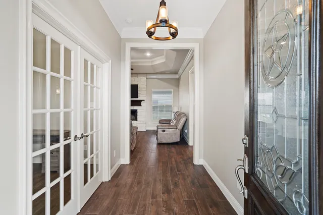 a view of a hallway with wooden floor and windows