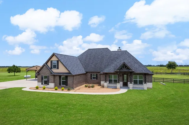 a front view of a house with yard patio and green space